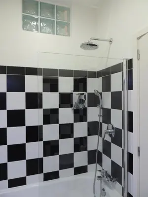 a bathroom with a black and white checkered wall at Rendez Vous Porto in Porto