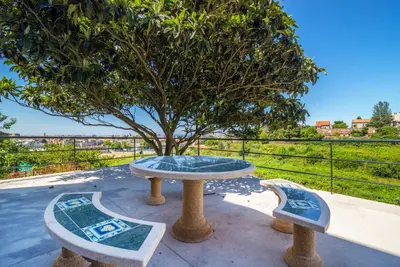 a table and two benches in front of a tree at Maredimo Village Porto Casa 1 in Porto
