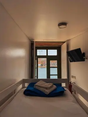 a bedroom with a bed with blue sheets and a window at Panorama Apartments Ribeira Porto in Porto