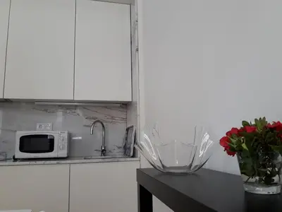 a kitchen with a counter with a microwave and a vase of flowers at Oporto Cosy Apartment at Alegria in Porto