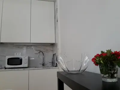 a kitchen counter with a vase of flowers and a microwave at Oporto Cosy Apartment at Alegria in Porto