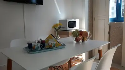 a white table with a plate of food on it at Oporto Cosy Apartment at Alegria in Porto