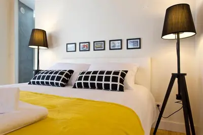 a bedroom with a bed with two black and yellow pillows at Ribeira Stay Apartments in Porto