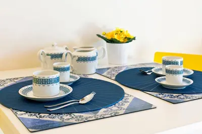 a table set with blue and white cups and saucers at Ribeira Stay Apartments in Porto