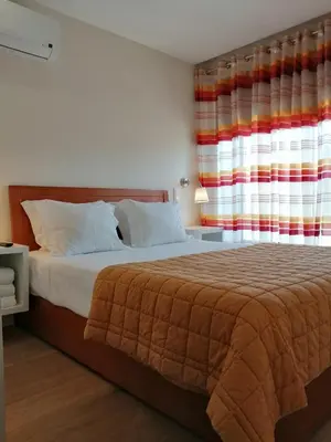 a bedroom with a bed and a large window at BC Porto Downtown Apartment in Porto