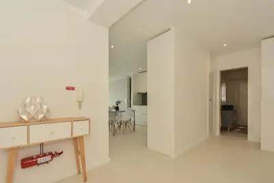 a living room with white walls and a wooden table at Downtown Prime Porto in Porto