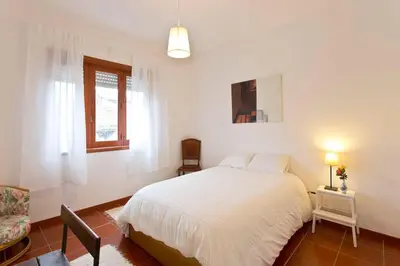 a bedroom with a bed and a chair and a window at Camarao Apartment in Porto
