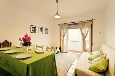 a living room with a green table and a couch at Camarao Apartment in Porto