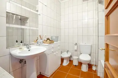 a white bathroom with a sink and a toilet at Camarao Apartment in Porto