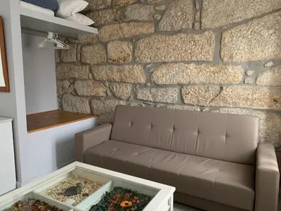 a living room with a couch and a stone wall at Campanhã Boutique Station in Porto