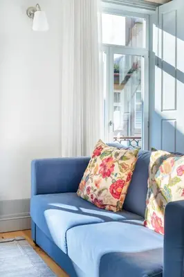 a blue couch with two pillows in a living room at AmaOporto - St. Ildefonso in Porto