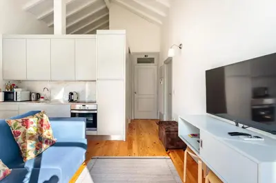 a living room with a blue couch and a kitchen at AmaOporto - St. Ildefonso in Porto