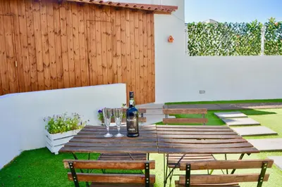 a wooden table with wine glasses and a bottle at Porto Garden Villas | Downtown in Vila Nova de Gaia