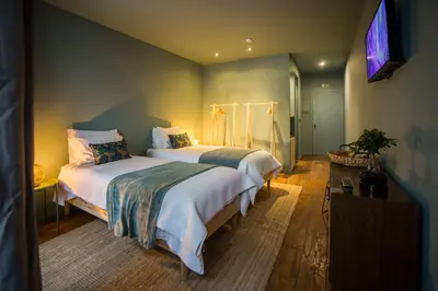 a bedroom with two beds and a flat screen tv at Laurear Guest House in Porto