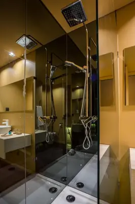 a glass shower in a bathroom with a sink at Laurear Guest House in Porto