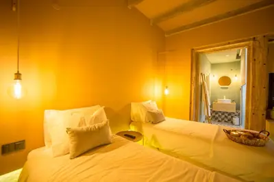 two beds in a room with yellow walls at Laurear Guest House in Porto