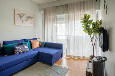 a blue couch in a living room with a window at GuestReady - Back to Little World in Porto
