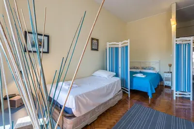 a bedroom with two beds with blue curtains at GuestReady - Minimalistic studio downtown in Porto
