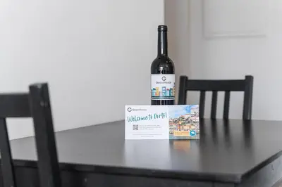 a bottle of wine sitting on a table with a book at GuestReady - Cosy spot near Porto city centre in Porto