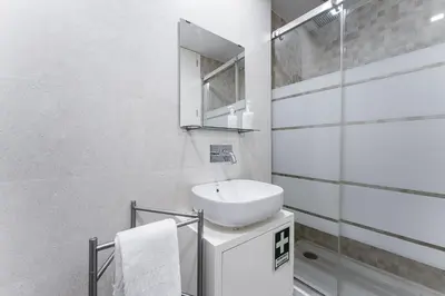a white bathroom with a sink and a mirror at GuestReady - Cosy spot near Porto city centre in Porto