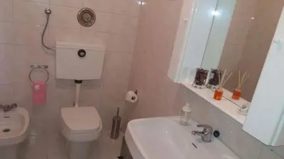 a bathroom with a toilet and a sink and a mirror at Quarto com 4 camas (Beliches+ 1 Sofá-cama) in Porto