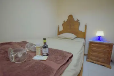 a bed with a bottle of wine and glasses on it at Quarto com 4 camas (Beliches+ 1 Sofá-cama) in Porto