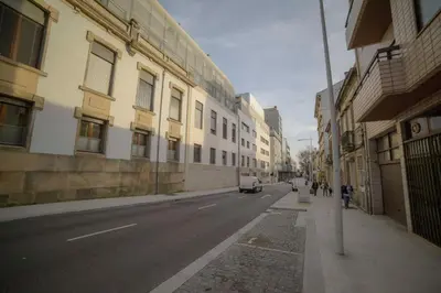 a city street with buildings and a car parked on the street at Quarto com 4 camas (Beliches+ 1 Sofá-cama) in Porto