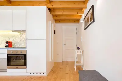 a kitchen with white cabinets and a ladder in a room at Almada Studio 419 in Porto
