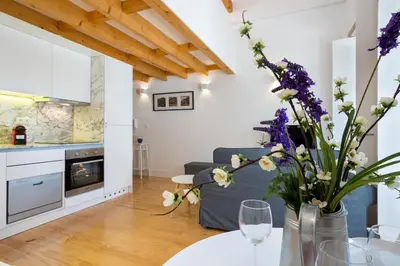 a living room with a couch and a table with flowers at Almada Studio 419 in Porto