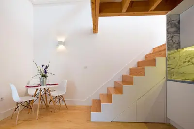 a white staircase in a room with a table and chairs at Almada Studio 419 in Porto