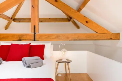 a bedroom with a white bed with red pillows at Almada Studio 419 in Porto
