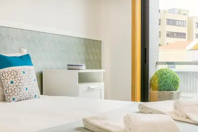 a bedroom with a bed with a pillow and a window at Camões Executive Flat in Porto