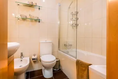 a bathroom with a toilet and a sink and a shower at Camões Executive Flat in Porto