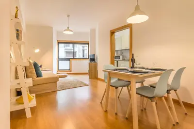 a dining room and living room with a table and chairs at Camões Executive Flat in Porto