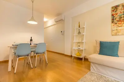 a living room with a table and chairs and a couch at Camões Executive Flat in Porto