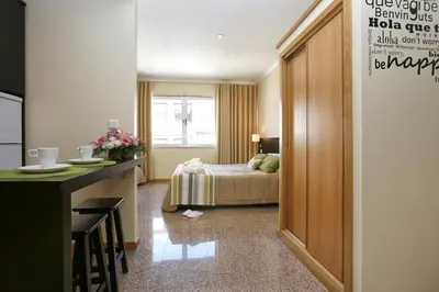 a hotel room with a bed and a desk and a kitchen at Oporto City Centre Apartments in Porto