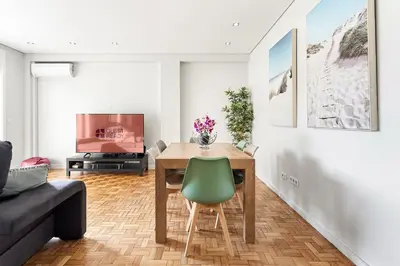 a living room with a wooden table and a green chair at GuestReady - Jupiter's Moon in Porto