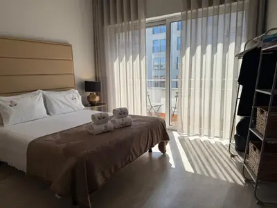 two teddy bears sitting on a bed in a bedroom at ML Apartments Almada panoramic balcony in Porto