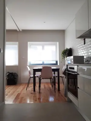 a kitchen with a table and chairs in a room at Porto Nascente in Porto