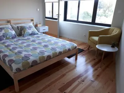 a bedroom with a bed and a chair at Porto Nascente in Porto