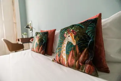 a bed with two pillows with a painting of a chicken at Adorable Apartments in Great Area in Porto