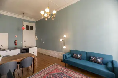 a living room with a blue couch and a table at Adorable Apartments in Great Area in Porto