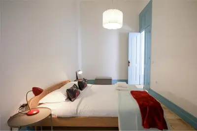 a bedroom with a large bed with a red blanket at Adorable Apartments in Great Area in Porto