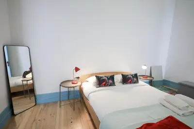 a bedroom with a large bed and a mirror at Adorable Apartments in Great Area in Porto
