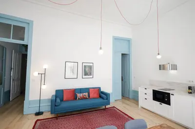 a living room with a blue couch and red pillows at Adorable Apartments in Great Area in Porto