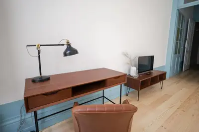 a desk with a lamp and a chair in a room at Adorable Apartments in Great Area in Porto