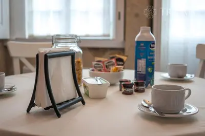 a table with a picture frame and cups on it at Oporto Center Clean & Cozy Apt 4th floor in Porto