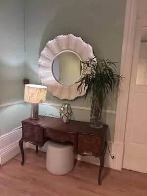 a mirror on top of a table with a vase at Monte Sinai Guest House in Porto