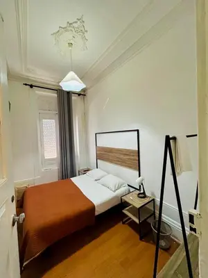 a bedroom with a bed and a table with a lamp at Monte Sinai Guest House in Porto