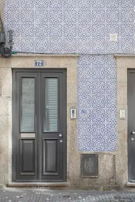 a door of a building with a blue and white wall at Liiiving in Porto - Historic Clérigos Apartments in Porto